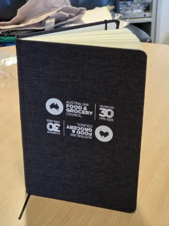 A dark gray notebook with the Australia Food & Grocery Council logo on the cover.