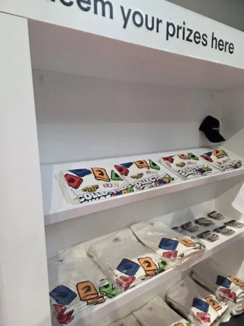 Colorful graphic t-shirts on white shelves—bulk orders welcome to avoid delays.