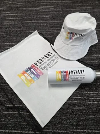 White hat, bag, and bottle with Prevent Trauma in Youth logo—ideal for advising clients.