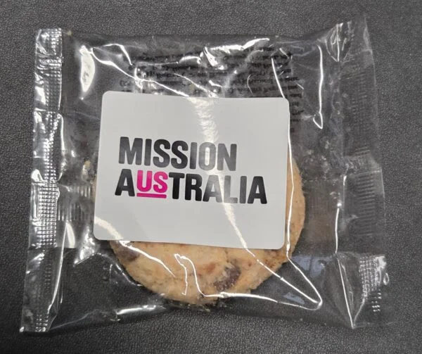 A cookie in clear packaging labeled MISSION AUSTRALIA, great for product comparison displays.