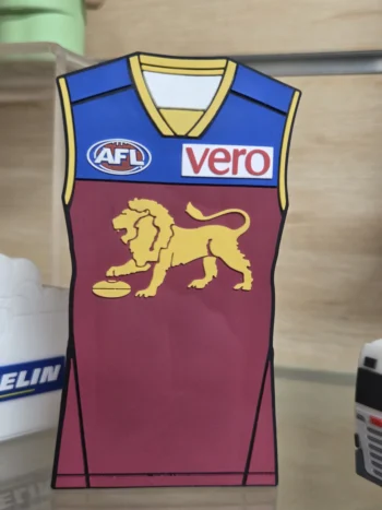 A maroon AFL apparel jersey with gold lion, blue shoulders, and printed AFL and vero logos.