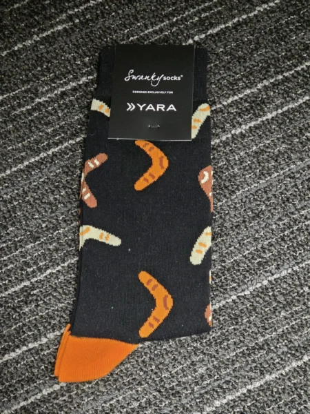 Black socks with orange accents and boomerang patterns, perfect for all ages events.