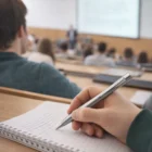 Student taking notes with a Parker Metal Pen Ballpoint Urban Metro Metallic CT in a lecture hall.