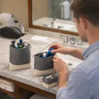 Man organizing toiletries in Griffith Recycled 3Pc Travel Pouches Sets on bathroom counter.