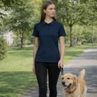 Wo's Amy Polos modeled by a woman walking a golden retriever on a leash in the sunny park.