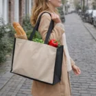 Woman with a Sadie Functional Tote Bag 26L carrying bread, broccoli, and a red bell pepper.