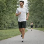 Man jogs in Active Training Shorts 19" on a park path; a woman walks ahead in the distance.