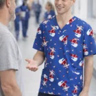 Smiling nurse in blue Merryvibe V-Neck Scrubs talks to a man in a hospital hallway.