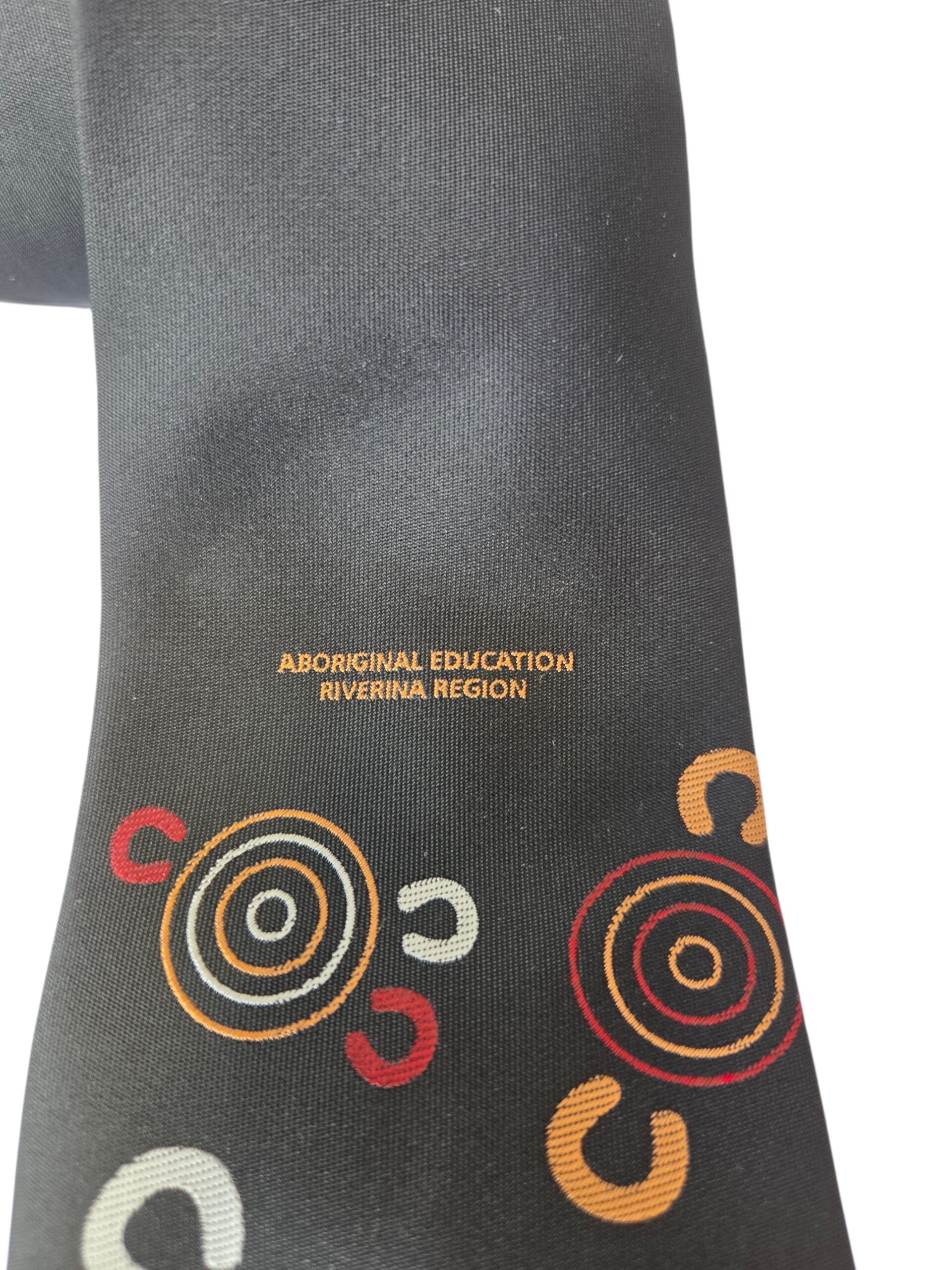 Black tie with colorful circles and text: Aboriginal Education, Riverina Region.