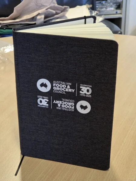 Dark notebook with Aussie business logo, marking Australian Food & Grocery Council's 30th year.