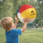 Young boy plays outdoors with a 34cm Bondii Beach Balls on grass.