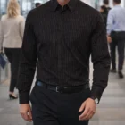 Man in a Mens Long Sleeve Pin Stripe Shirt walks in a modern office hallway.