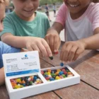 Three kids smile as they pick Colourful Jelly Goodies from a box with a business card.