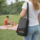 Woman holding a México bag and Wine Cooler Bags, heading toward a picnic on a grassy field.