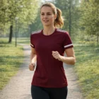 Woman jogging in Adidas 3-Stripe Women's T-Shirts on a sunny park path among green trees.