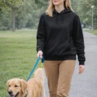 Woman in a Ky Adult's Close Front Contrast Fleecy Hoodie walks a golden retriever in the park.