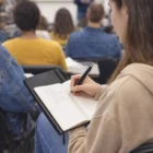 A student takes notes in a Nova Bound Journalbooks during a classroom lecture.