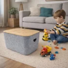 Young boy playing with toy trucks near Ava Tubs storage bin in a living room.