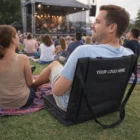 Man enjoying a concert on Advance Stadium Seats with your logo displayed on the chair back.