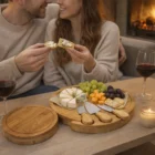 A couple enjoys wine and cheese by the fireplace with a 5Pc Set Cheese Boards.