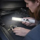 Using a Raxis Torches flashlight to search for car keys under a car seat.