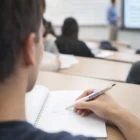 Student takes notes with Marlow Mac Pens during a classroom lecture.