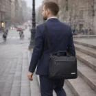 Man in suit with an Antonio Briefcase Ruanses, walking up city steps on a cloudy day.