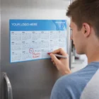 Writing "Physics Exam!" on Magnetic Tab Calendars for October 15 on the fridge.