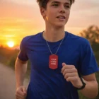 Teen boy jogging at sunset, wearing a blue shirt and a Coloured Dogchains 76Cm Ballchain.