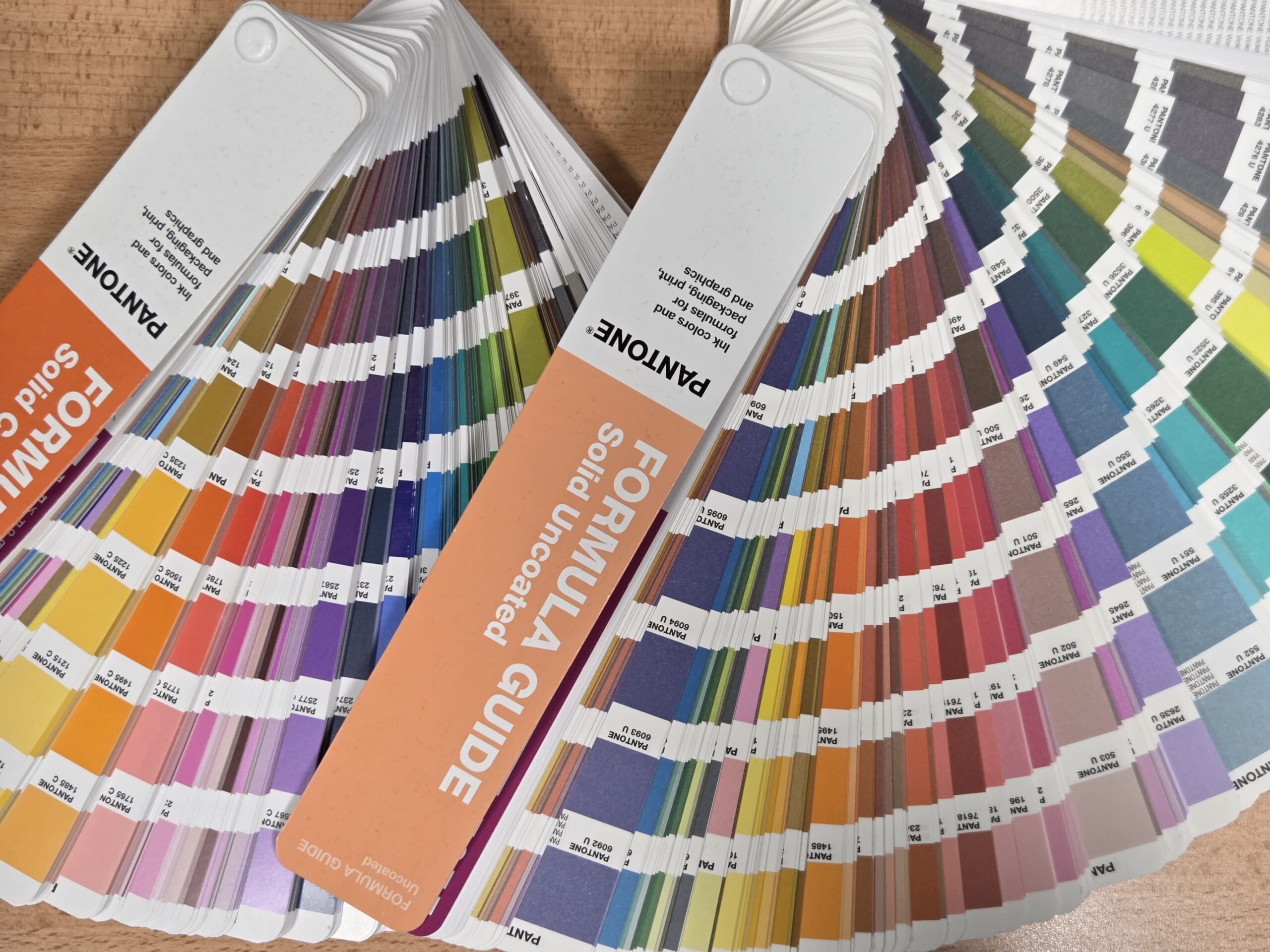 Pantone color formula guides fanned out, ideal for brand guidelines and production limitations.