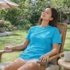 Woman enjoys the sun outdoors in an American Apparel 2001 T-Shirt, eyes closed and relaxed.