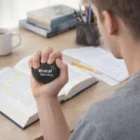 Person at a desk squeezes a Stress Ball - Local Service.