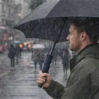 Man holding a Linus Umbrellas product in the rain on a busy city street.