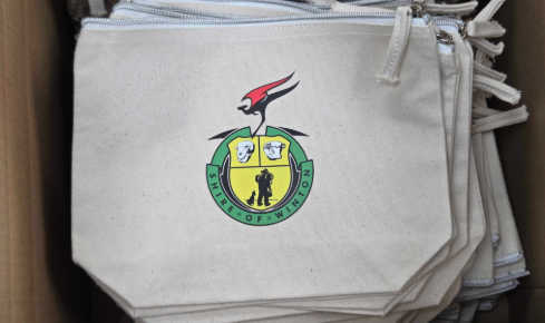 Beige pouches with Winton Shire Council crest and zipper neatly stacked in a box.