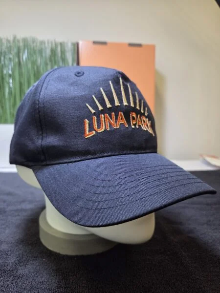 Navy blue cap with Luna Park and yellow rays, built for heavy use and print durability.