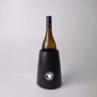 A wine bottle in a black Fjällräven-branded wine cooler against a plain background.