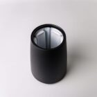 Black, cylindrical container with a divided interior, photographed from above on a white background.