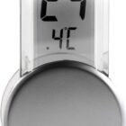 Digital thermometer displaying 24.4°C with a silver circular base, transparent body.