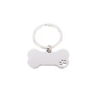 Silver bone-shaped keychain with small paw print cutout on one end, on white background.