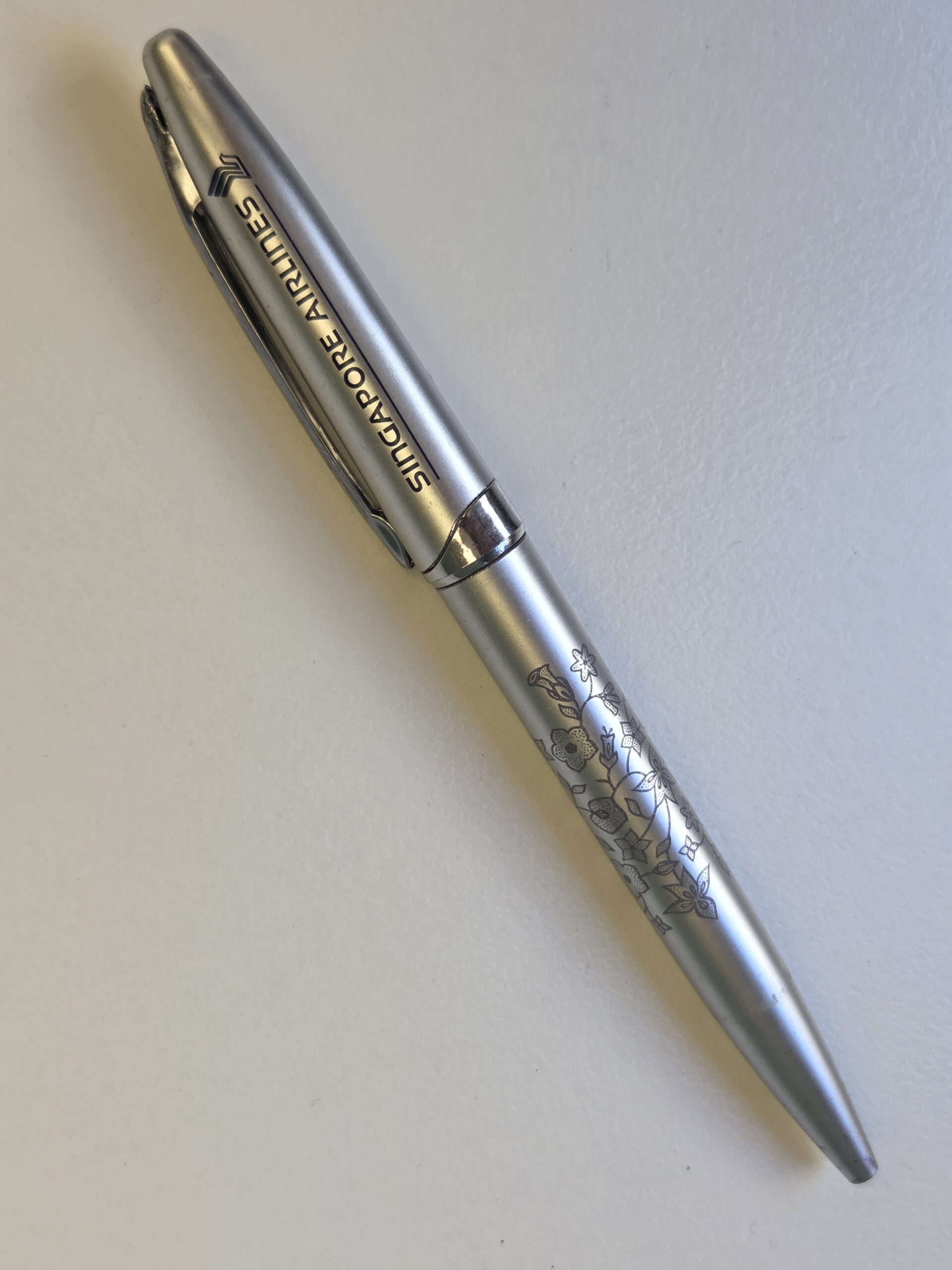 A silver Singapore Airlines pen, ideal for corporate gifts, on a white surface.