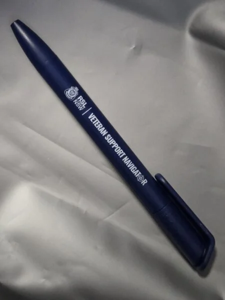 A blue pen labeled Veteran Support Navigator on a gray fabric, supporting Aussie business needs.