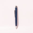 A blue ballpoint pen with a silver tip and clip, casting a shadow on a light background.