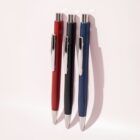 Three retractable pens in red, black, and blue with silver clips and tips on a light background.