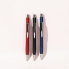 Three pens—red, black, and blue—standing upright against a light background with shadows.