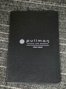 Black Pullman Hotels and Resorts folder on gray carpet—ideal for client gifts or financial planners.