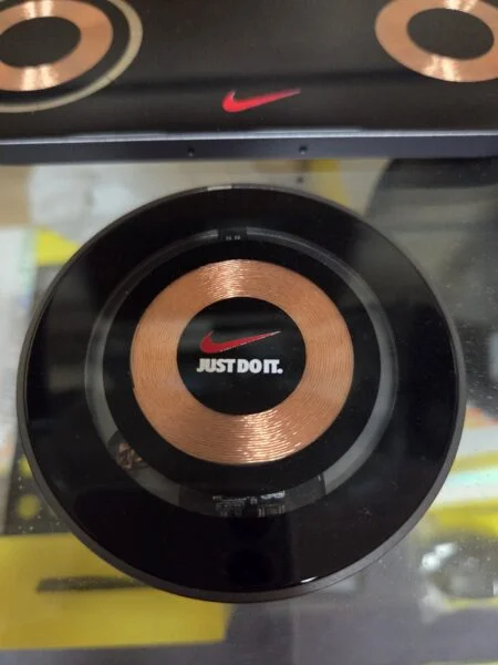 Round wireless charger with copper coil, Nike logo, Just Don. for retail restocking needs.