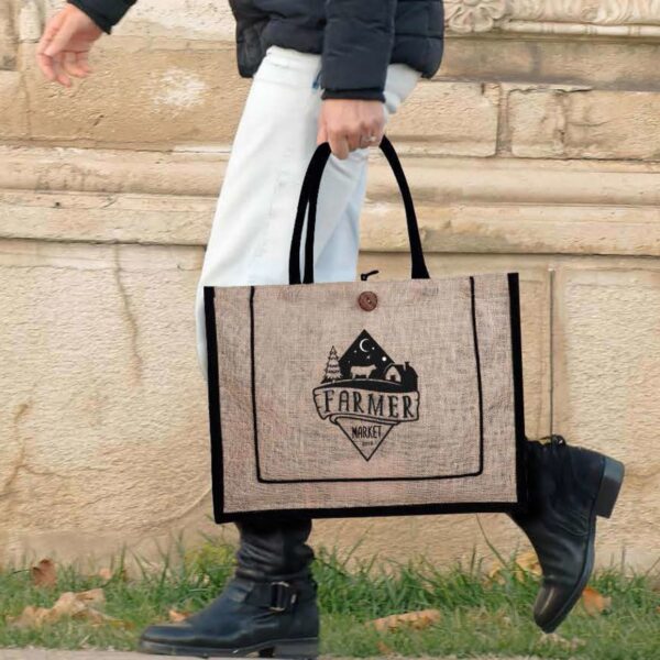 Person walking with a tote bag that reads Farmer Market and features a farm graphic.