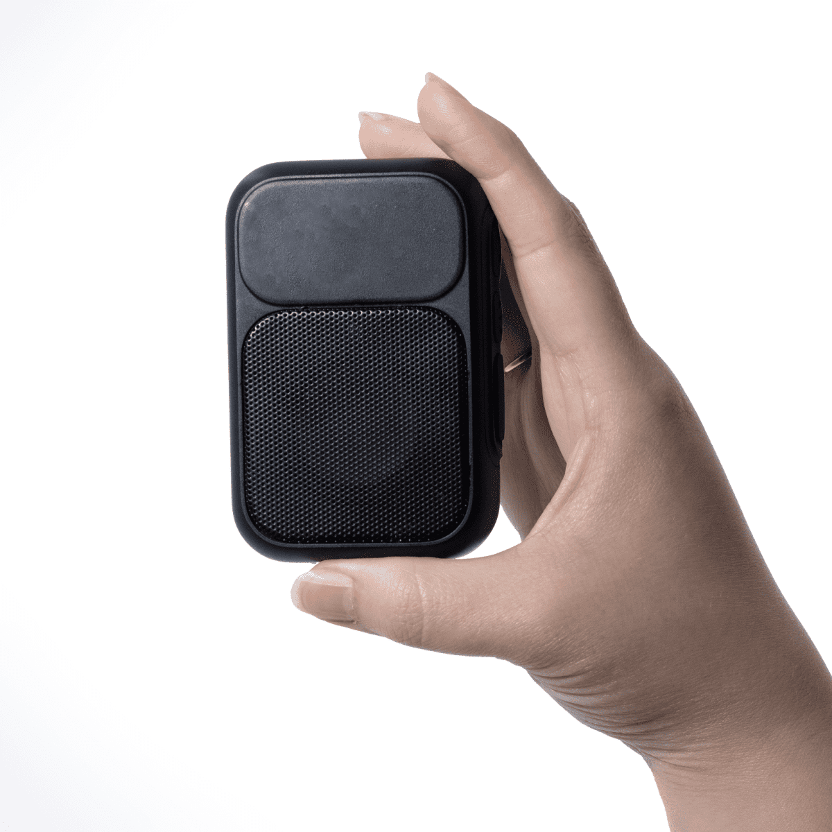 A hand holding a small, black, rectangular portable speaker against a white background.
