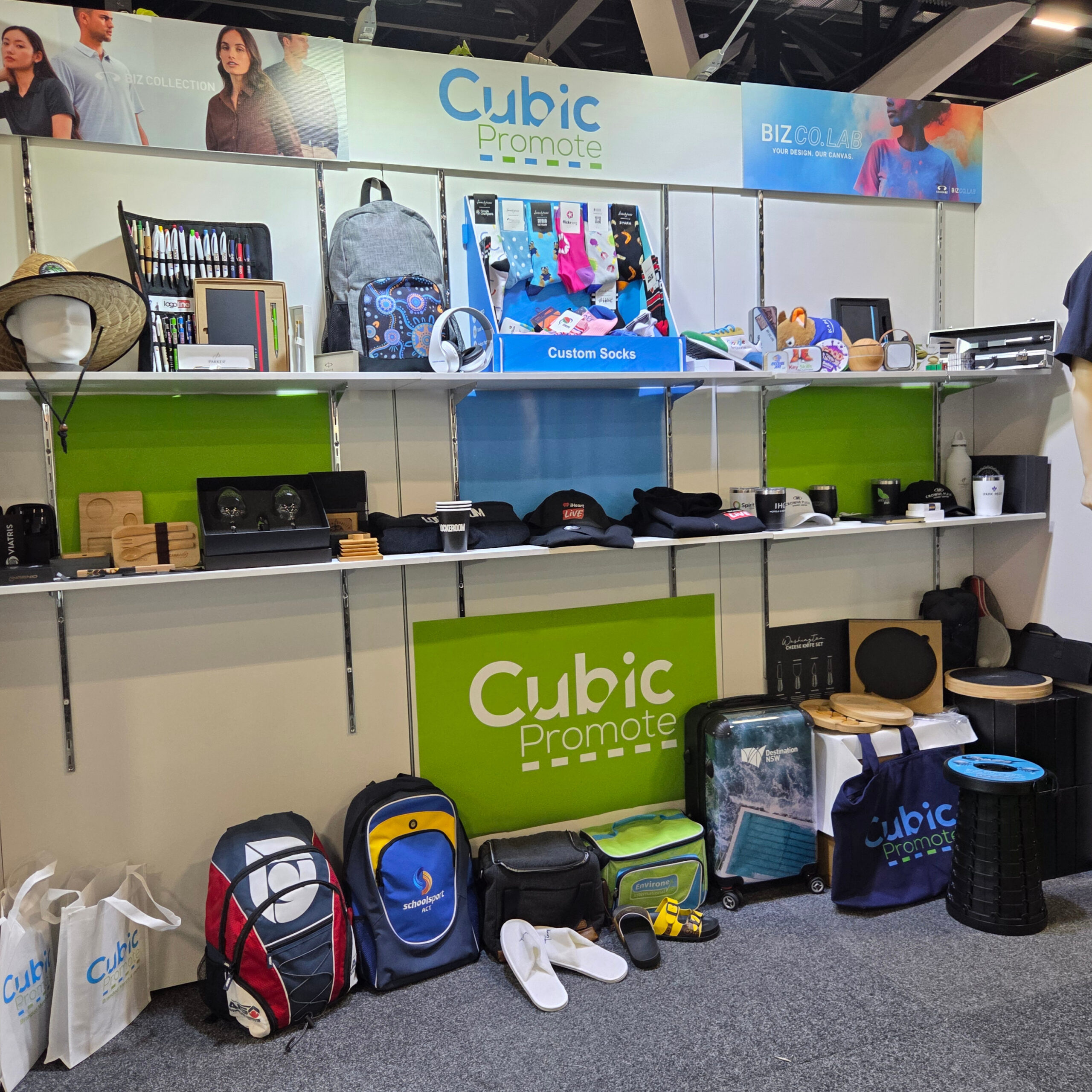 Shelves and floor display with bags, hats, mugs, and products for trade shows.