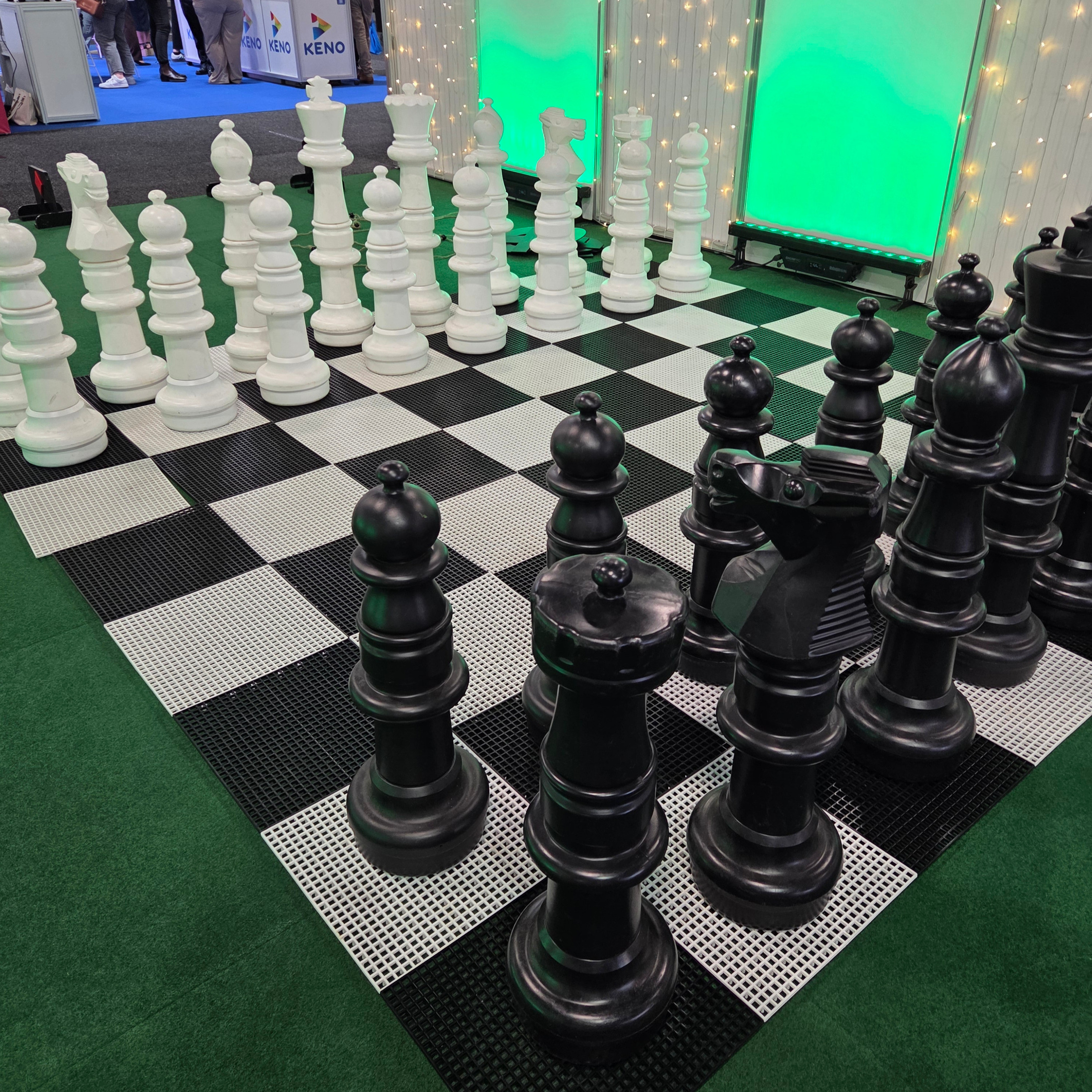 Large black and white chess pieces on a checkered floor—great products for trade shows.